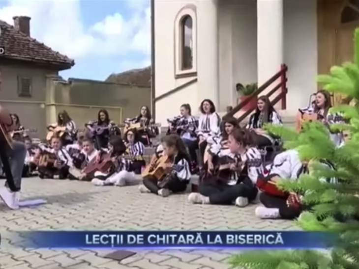 Copiii din Sadu, învățați să cânte la chitară de preotul localității. Lecțiile sunt gratuite